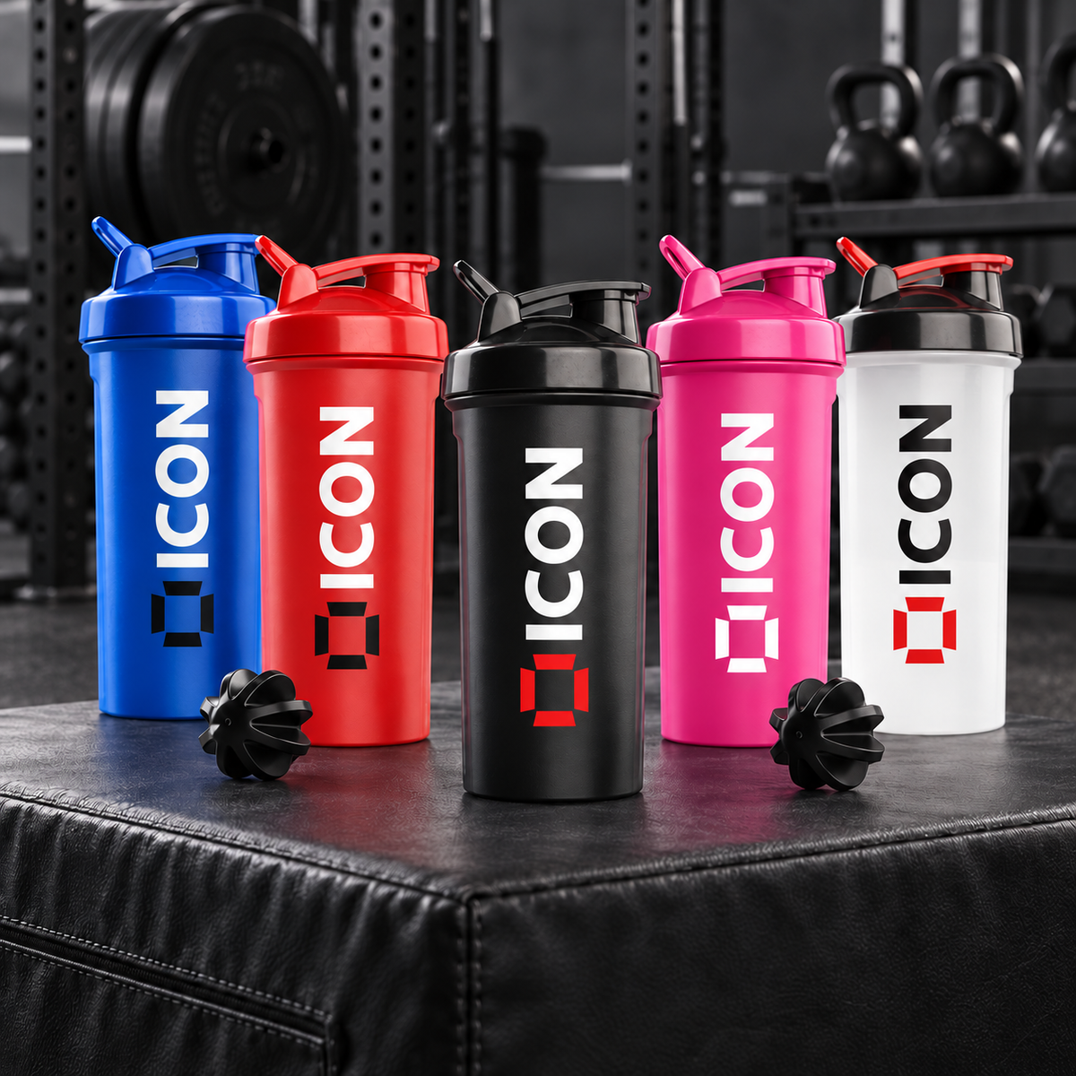 Five coloured ICON 700ml protein shakers in a gym